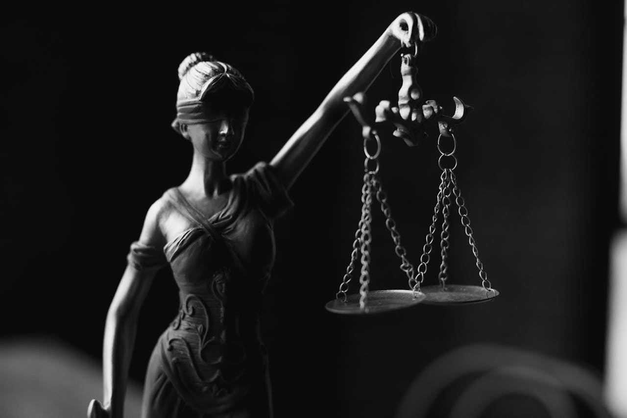Services-03 A close-up black and white photo of the Lady Justice figurine with scales.